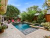 Backyard oasis with pool, lounge chairs, and lush greenery under clear blue skies. Perfect for relaxation and outdoor enjoyment