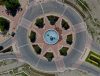 Aerial view of a circular roundabout with a central fountain and greenery, featuring star-shaped brick patterns