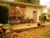 Charming backyard patio with vintage decor, metal chairs, and autumn leaves covering the ground