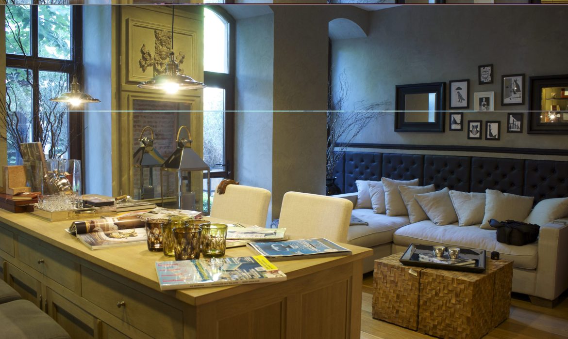 A bright living room showcasing a central table with four chairs, complemented by warm decor and inviting ambiance