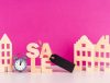 Wooden blocks spelling "Sale" on a vibrant pink background, emphasizing a promotional offer